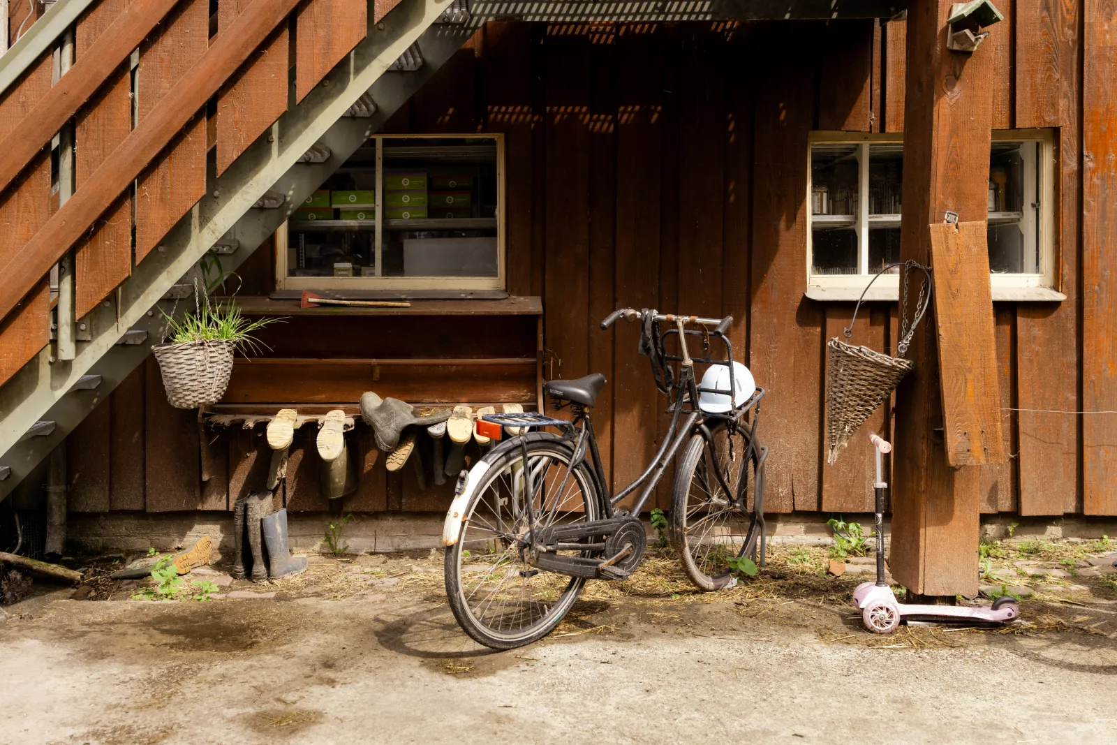 Een fiets met een helm staat tegen een huis op de Ridammerhoeve geparkeerd.